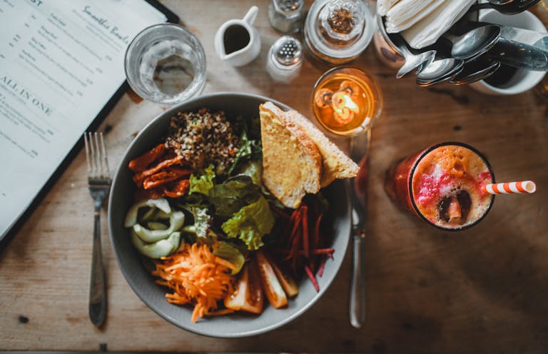 A vibrant, delicious vegetarian bowl with fresh juice served at a cozy café, ideal for health-conscious diners.