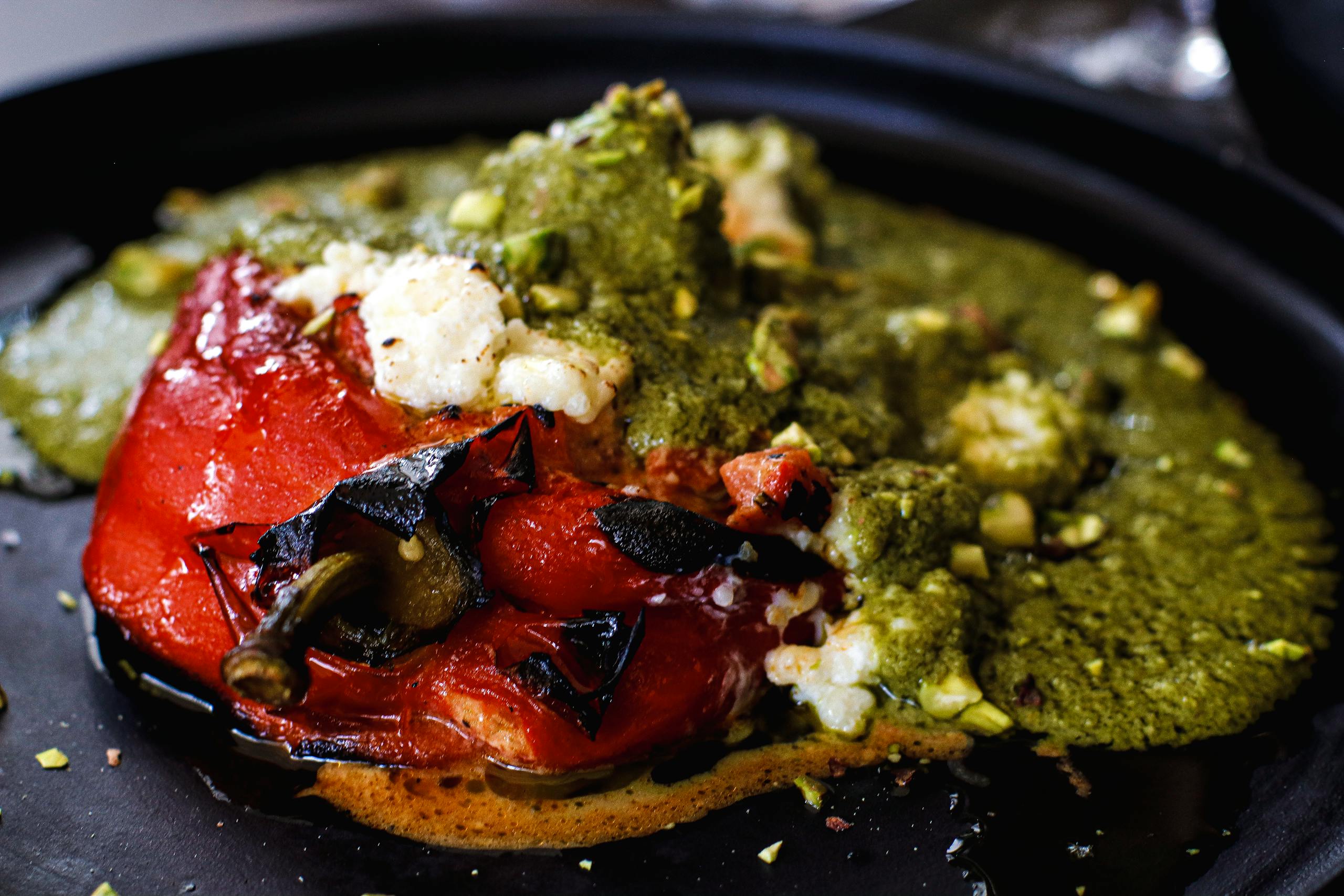 Close-up of a traditional Mexican stuffed chili pepper topped with green sauce, served in Mexico City.