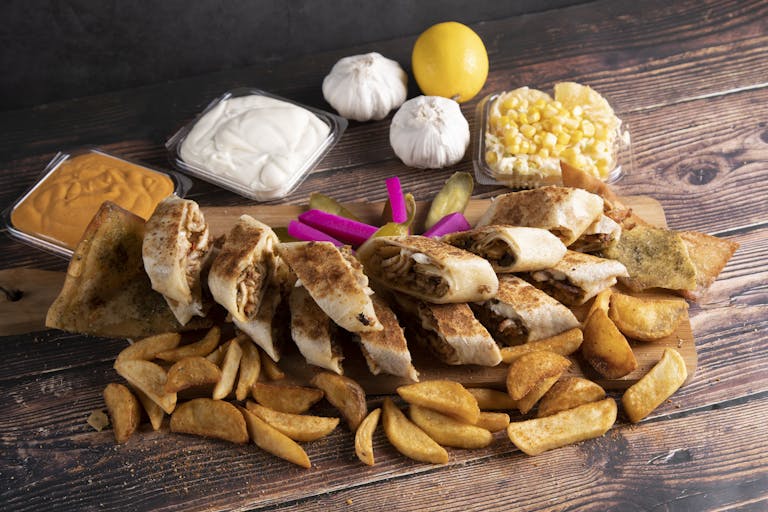 Delicious Middle Eastern wrap platter with fries, served with garlic sauce and hummus.
