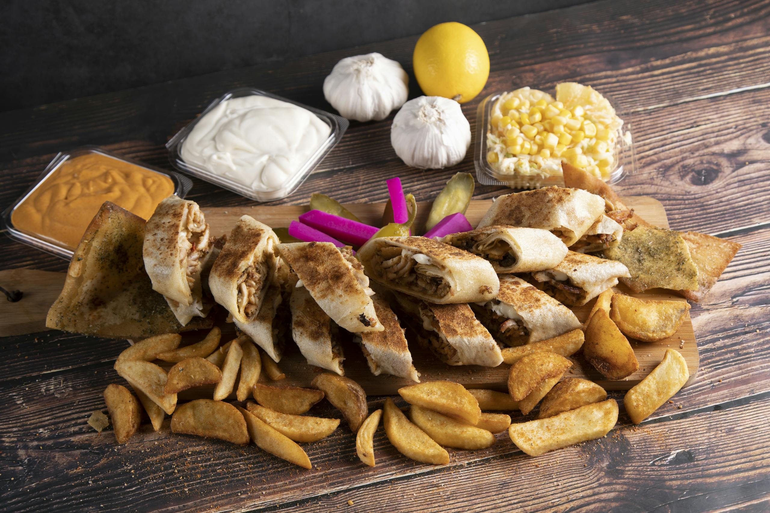 Delicious Middle Eastern wrap platter with fries, served with garlic sauce and hummus.